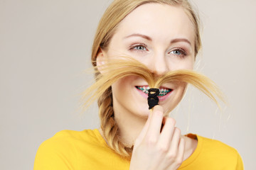 Woman making moustache out of blonde hair