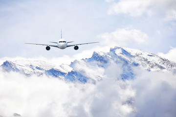 Airplane flying over snow mountains in winter