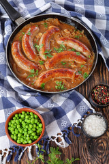 juicy fried sausages and green peas