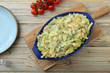 pasta gratinata maccheroni al forno con zucchini mandorle e formaggio su sfondo tavolo di cucina