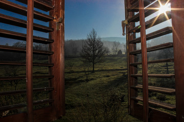 Fototapeta na wymiar sunrise view seen through old wooden window