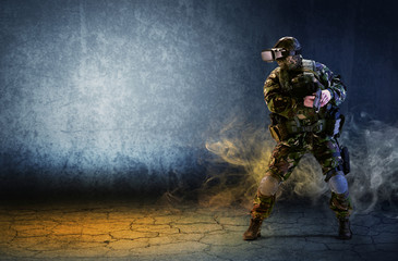 A soldier with virtual reality glasses is holding a pistol in his hands.