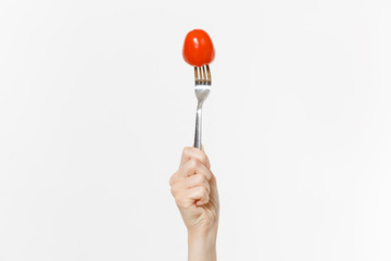 Close up female holds in hand red fresh tomato on fork isolated on white background. Proper...