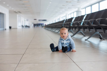 Obraz premium Little child, baby boy, playing at the airport, while waiting for his plane to departure