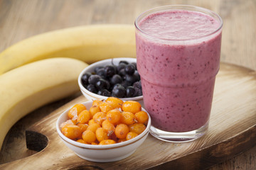 Smoothies with buckthorn, blueberries and a banana in a glass