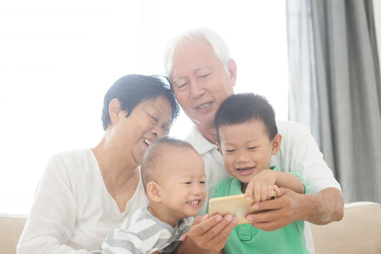 Grandparents and grandchildren taking selfie using smart phones