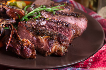 Slices of beef steak served with baked artichoke