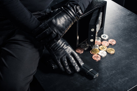 Close-up view of criminal opening safe with bitcoin cryptocurrency