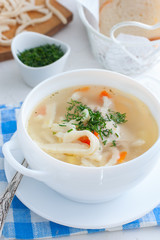 Hot homemade soup on chicken broth with homemade noodles in a white cup, selective focus