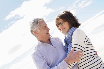 Obraz premium Portrait of senior couple embracing by the beach