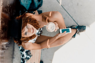 Top view portrait of woman sitting on skateboard.