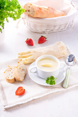 asparagus cream soup with capers and fresh baguette