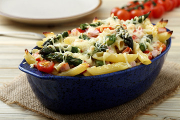 pasta gratinata maccheroni al forno con verdure e legumi vari su sfondo tavolo di cucina