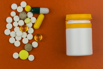 Capsules and tablets. Pharmaceutical medicine concept. Orange texture