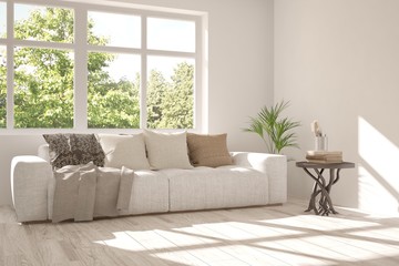 Fototapeta premium Idea of white room with sofa and summer landscape in window. Scandinavian interior design. 3D illustration