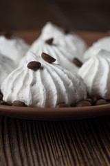 Sweet dessert - vanilla marshmallow (zephyr) on a wooden table with coffee beans, selective focus.