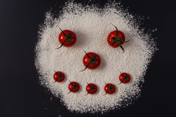 Tomatoes and flour on a black background