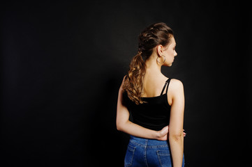 Studio portrait of back hairdress brunette girl  on black background.