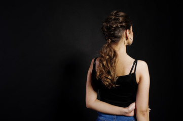 Studio portrait of back hairdress brunette girl  on black background.