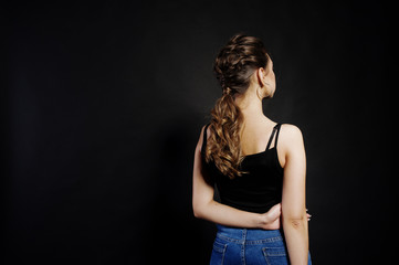 Naklejka premium Studio portrait of back hairdress brunette girl on black background.