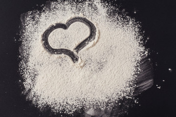 Heart shape on the background of flour. Concept