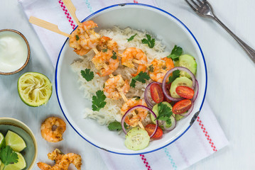 Tandoori prawn skewers with rice and chopped salad - top view