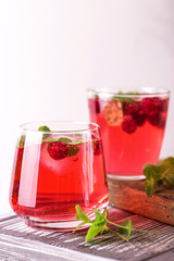 Fototapeta na wymiar Aperitif with campari, mint and raspberry. Iced lemonade