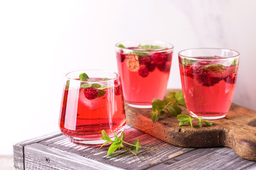 Fototapeta na wymiar Aperitif with campari, mint and raspberry. Iced lemonade