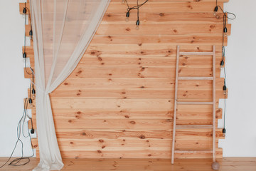 A wooden photozone, decorated with hops, with tlight bulbs and ladder. Copy space for text