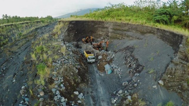 Excavator and truck take volcanic ash from the outflowing river. Legazpi city. The Mayon Volcano. Philippines.