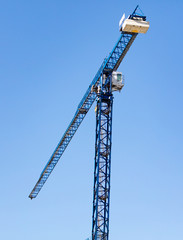 Tower crane on a construction site against a blue sky