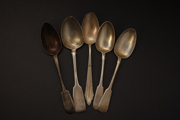 set of antique silver spoons on a dark background