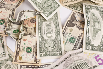 Pile of various US american dollar money bills spread on white background.