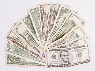 Pile of various US american dollar money bills spread on white background.