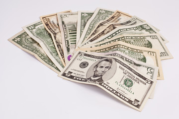 Pile of various US american dollar money bills spread on white background.