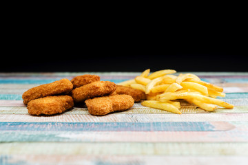 Chicken nuggets with sauce and golden French fries potatoes