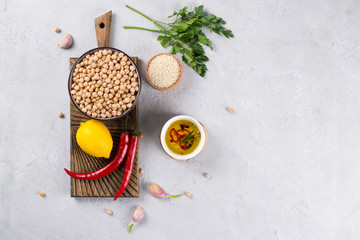 Main ingredients for making hummus, chickpea, lemon, garlic, sesame, oil, pepper, parsley top view.Food background with copy space