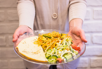 Egg omelette with pasta and vegetables on a transparent plate