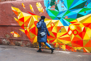 girl walking along the colorful wall, street photo