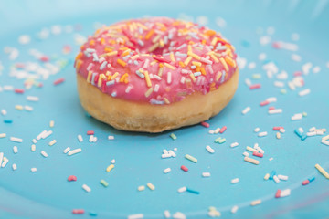 Pink donuts with sprinkles on blue background