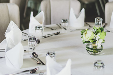 Table setting for dining room, the table is decorated with flowers,Fine table setting in a luxurious restaurant