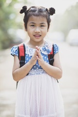 thai children posting sawasdee acting toothy smiling face outdoor