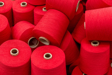 a large pile of spools of red thread. close up