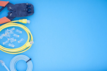 SKS and engineering concept. Set of connectors, ethernet and console cables, crimp tool on the blue...