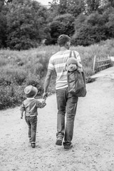 Father and son. Loving family and summer vacation. Man and kid boy playing together outdoors. Dad carrying child on nature.