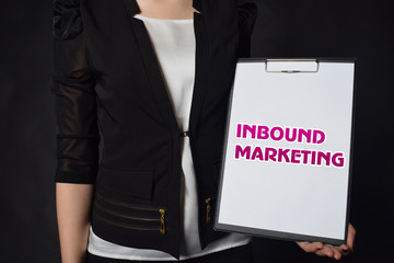In the hands of a businessman a notebook with the inscription:INBOUND MARKETING