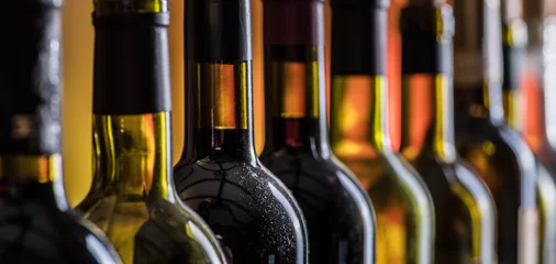 Foto op Plexiglas Lijn van wijnflessen. Detailopname. © volff