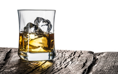 Whiskey glass or glass of whiskey with ice cubes on the table at white background.