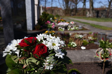 Friedhof mit Blumenschmuck und Kerzen