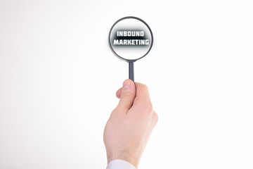 Businessman looking at a magnifying glass word:INBOUND MARKETING